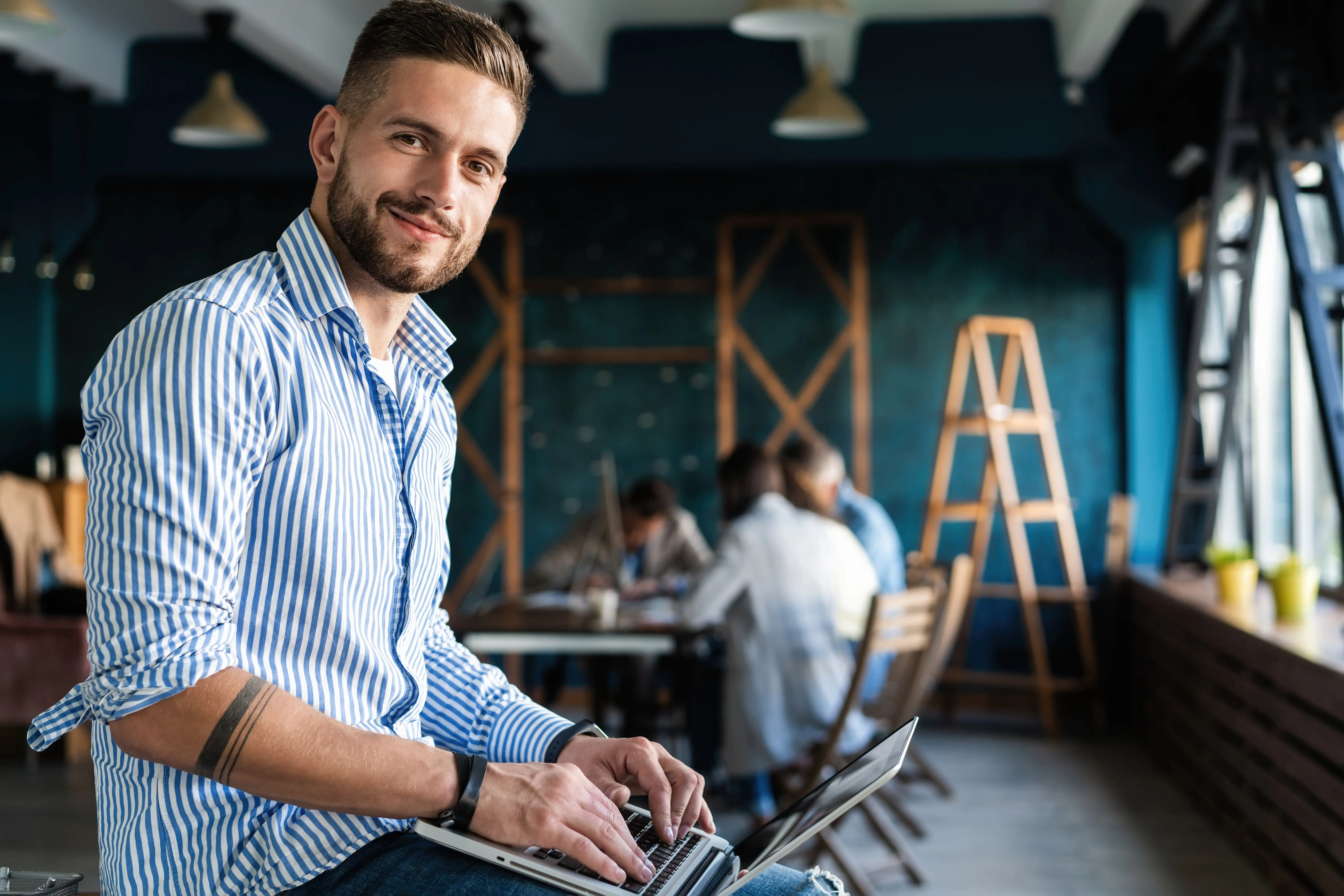Junger Mann mit Laptop in einem modernen Büro